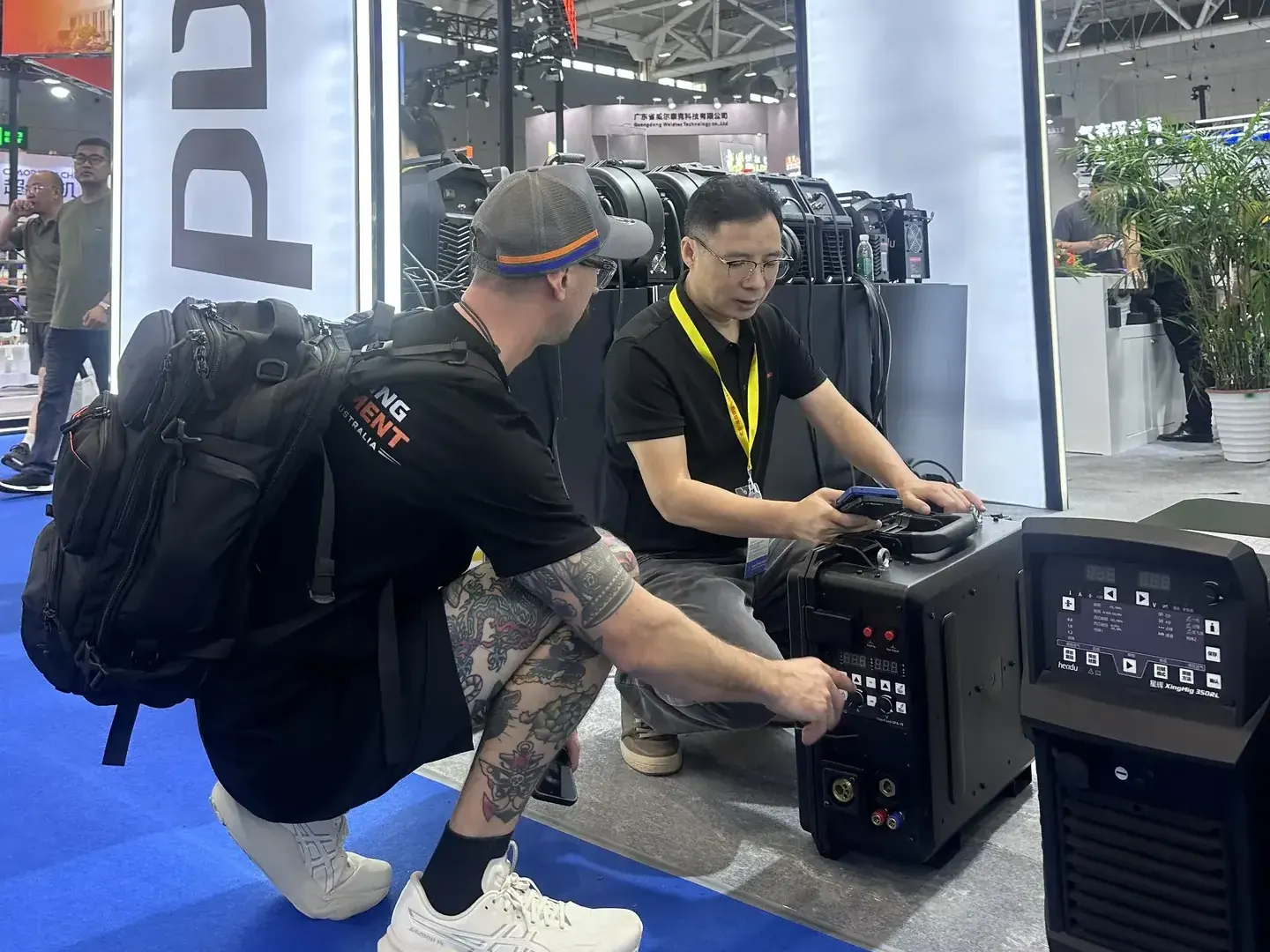 International visitor learning about HEADUX welding equipment at Beijing Essen 2026